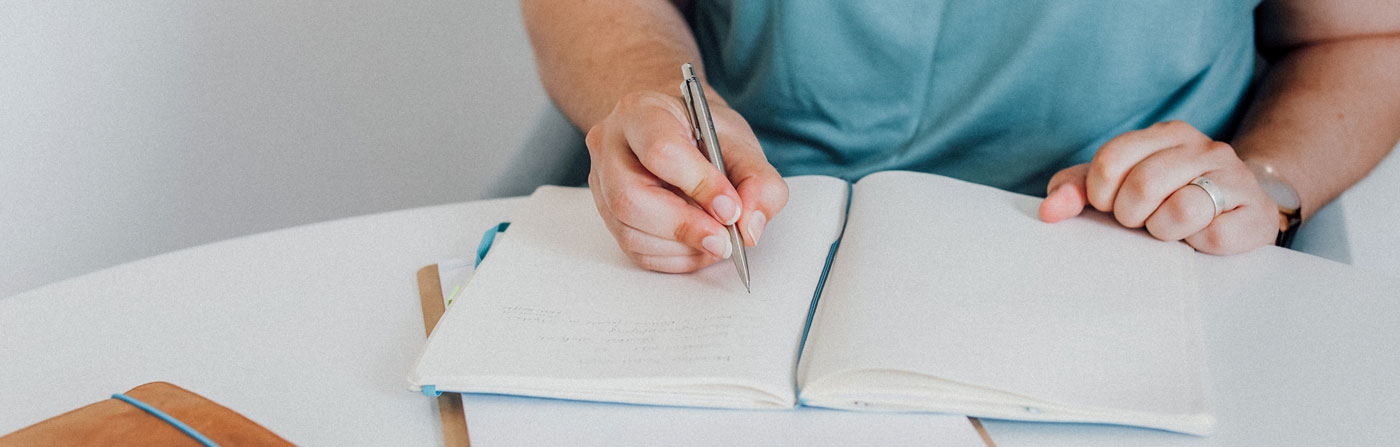 Melanie Bangert schreibt in ein Notizbuch | Buchprojekt